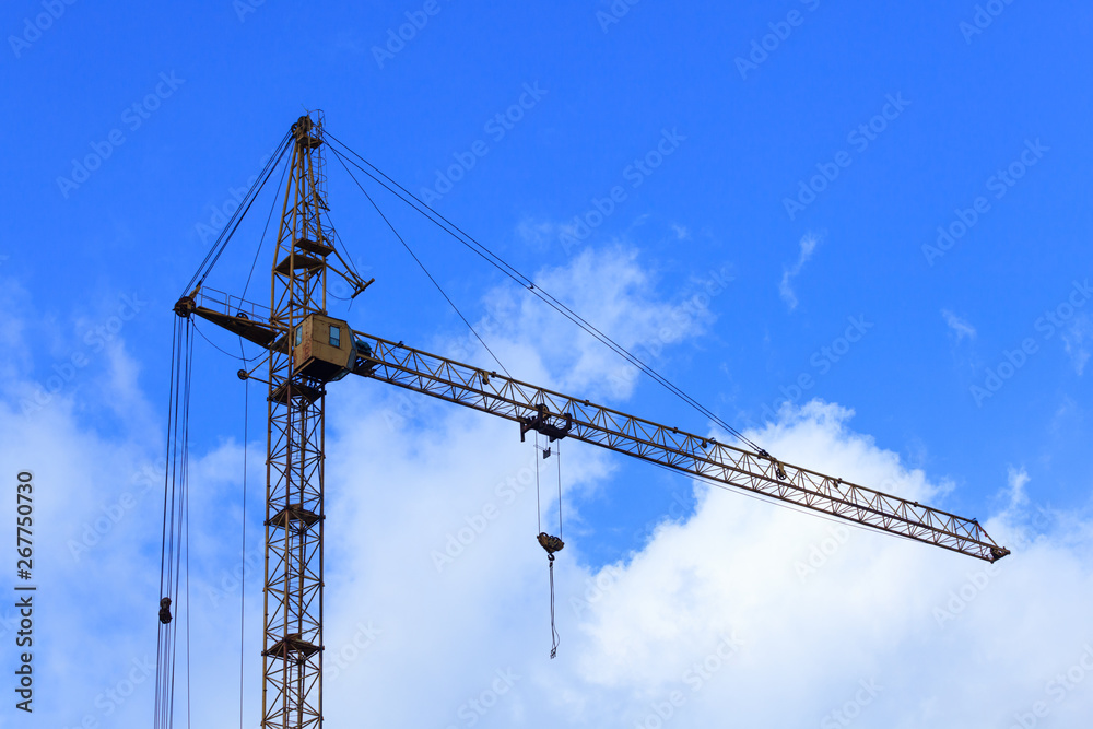 Construction crane against the blue sky background.