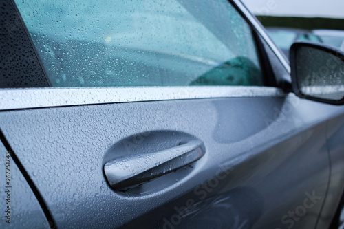 Close up of wet handle of door car after raining. Water drops on a car door handle.