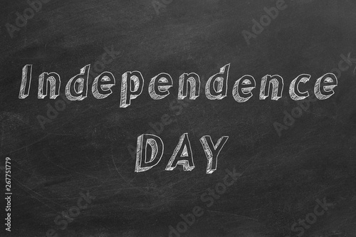 Hand drawing text "Independence Day" on blackboard