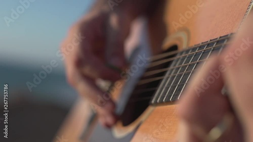 Man Playing and tuning acoustic Guitar Close Up shot side angle shot outdoor