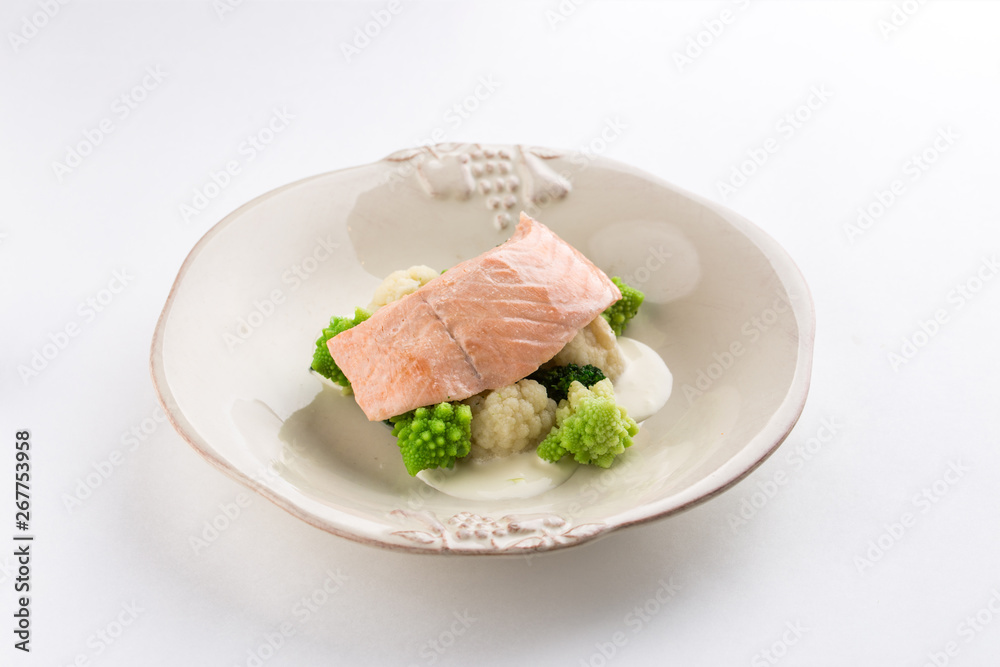 Steamed salmon, cauliflower and broccoli on white plate isolated on white background Steamed salmon, cauliflower and broccoli on white plate isolated on white background