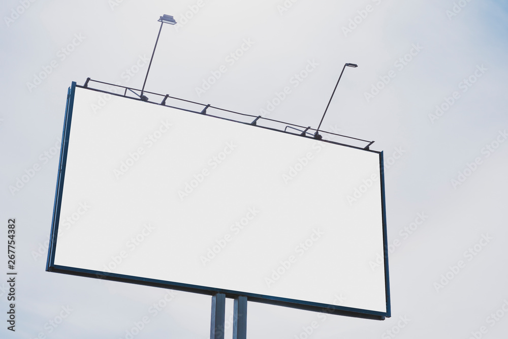 Billboard on the background of a beautiful white cloudy sky. Mock up for your advertising or announcements