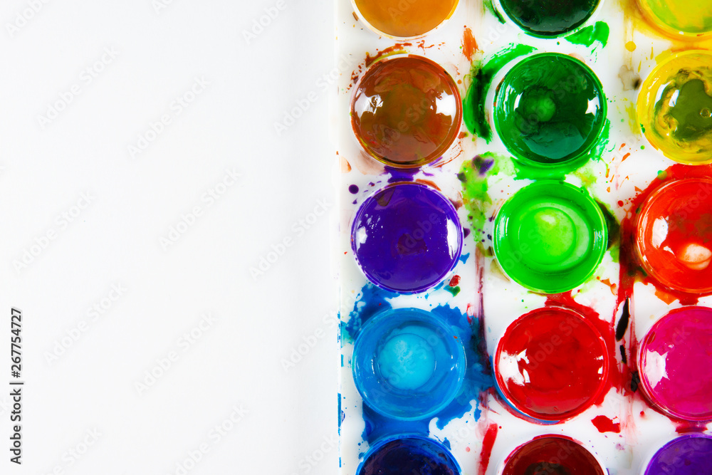 A set of children's paints in circular forms close-up. Copy space for text