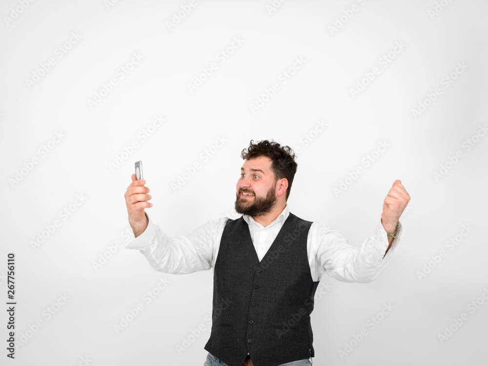 young man with black beard is posing and looking at his smartphone in front of white background with different emotions young man with black beard is posing and looking at his smartphone in front of white background with different emotions