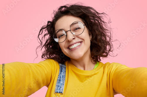 Cheerful young woman taking selfie photo