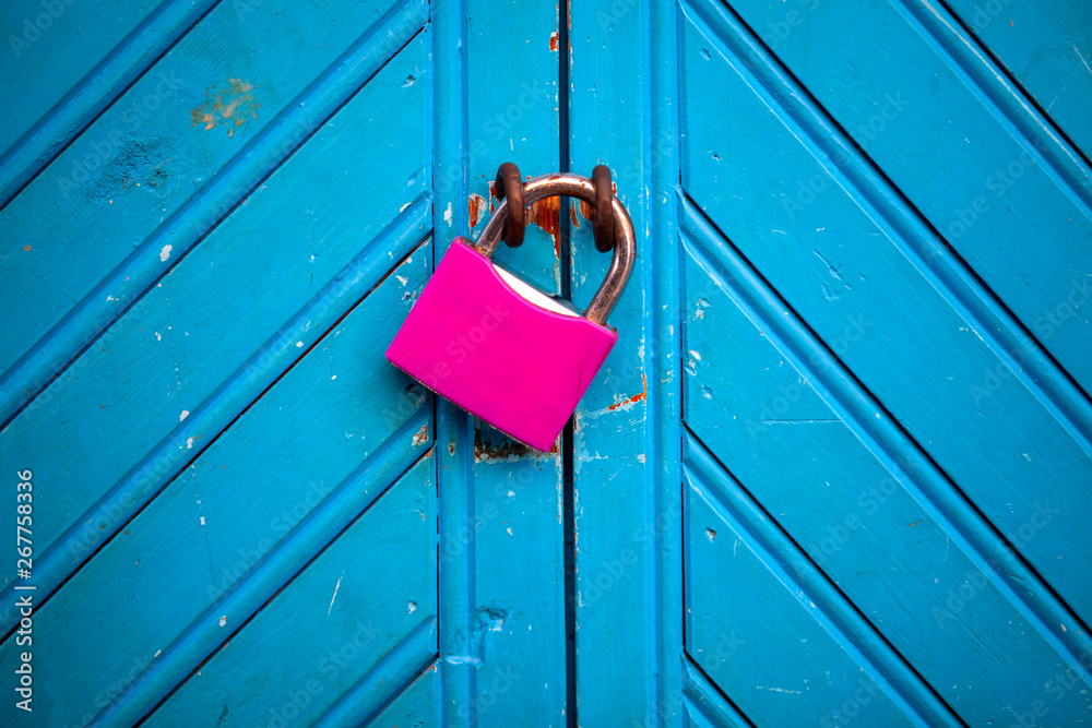 Candado fucsia sobre puerta azul