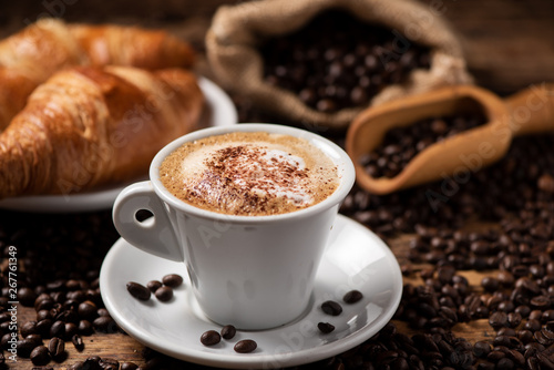 A cup of cappuccino with coffee bean as background. Fototapet