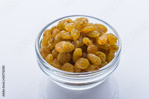 golden raisins on a white acrylic background