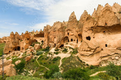 Hoodoos of Cappadocia. Big rocks carved by wind and water through time. Clouds and grass. Caves of Cappadocia, Nevsehir / Turkey