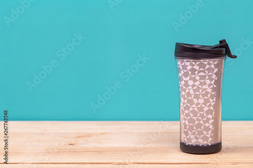 plastic tumbler glasses or thermos travel cup isolated on wooden background