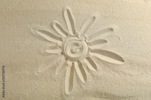 Sun drawing on clear sea sand, space for text and top view. Summer vacation background