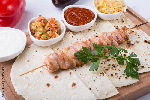 Cooked chicken kebab on a wooden board