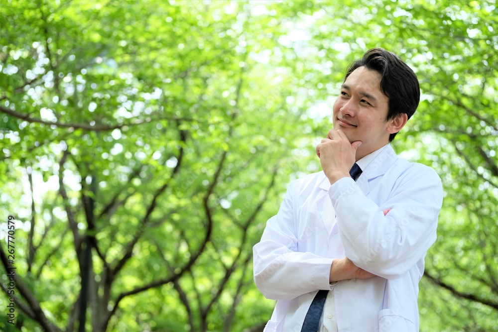 ポージングをする男性医師　信頼　新緑の公園　二十代　三十代