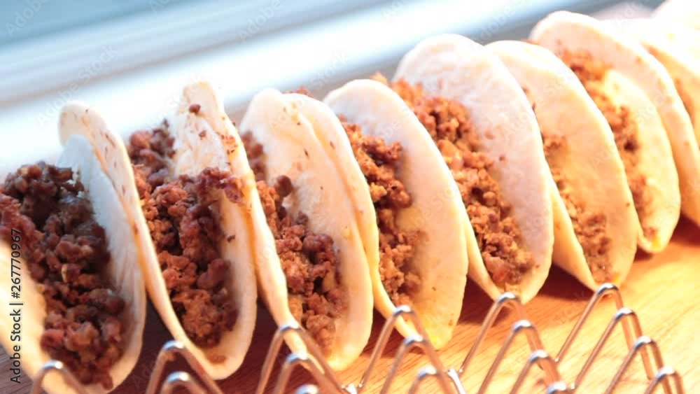 Close up of soft beef tacos on rack left to right