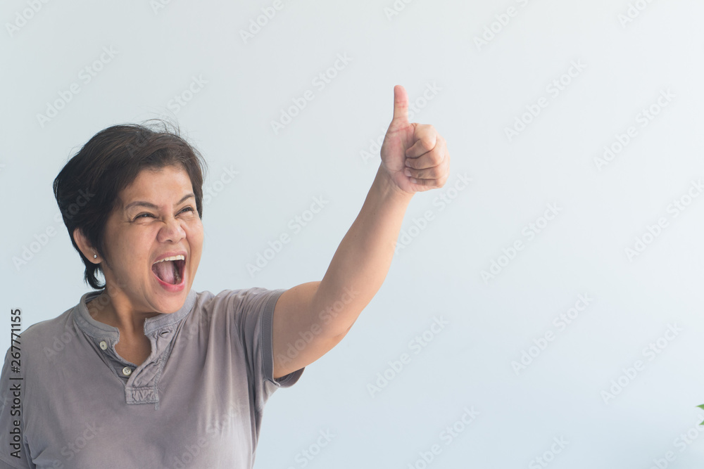 middle aged asian woman giving yes, ok, approving thumb up gesture middle aged asian woman giving yes, ok, approving thumb up gesture