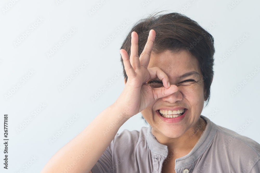 middle aged asian woman giving approving, accepting, yes, ok or okay gesture