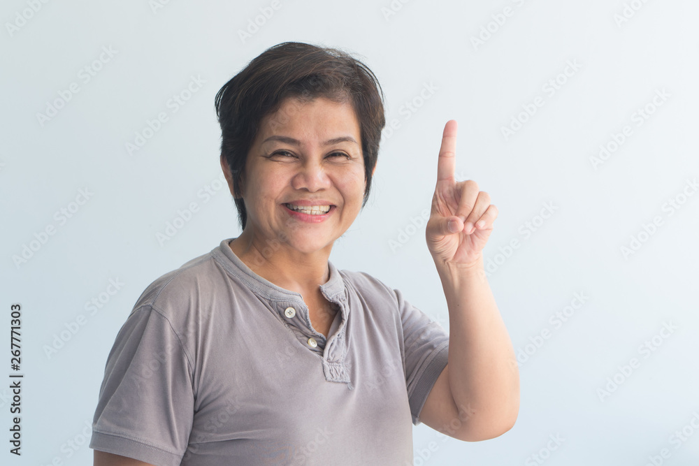 happy smiling Asian senior woman pointing up 1 finger happy smiling Asian senior woman pointing up 1 finger