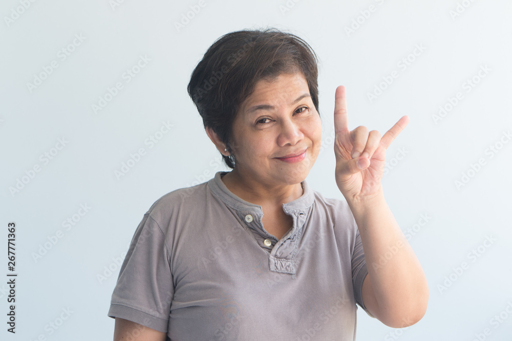 happy smiling Asian senior woman pointing up love and peace hand sign happy smiling Asian senior woman pointing up love and peace hand sign