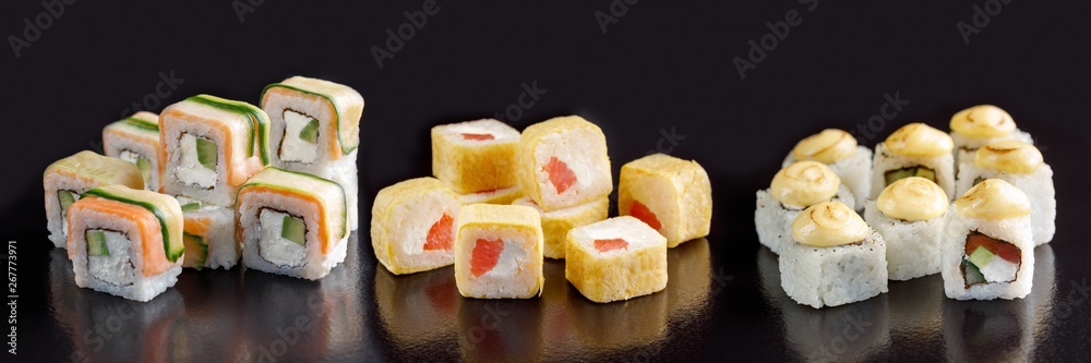 Elite sushi rolls on a black background. Assortment of rolls with different fillings.