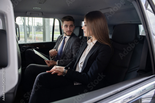 Conversation of two business people in driving car
