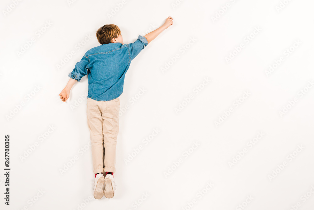 top view of kid lying and gesturing on white top view of kid lying and gesturing on white