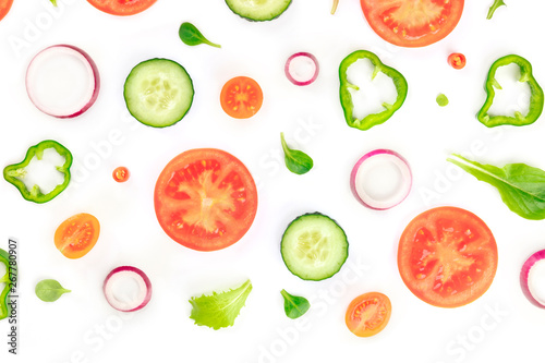 Fototapeta Naklejka Na Ścianę i Meble -  Fresh vegetable salad ingredients, shot from the top on a white background. A flat lay composition with tomato, cucumber, peppers, onion slices and mezclun leaves