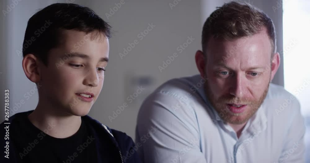 4K Father & son looking at laptop, browsing the internet & chatting. Slow motion. 4K Father & son looking at laptop, browsing the internet & chatting. Slow motion.