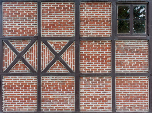 non-standard crosses on a checkered brick Scandinavian wall with a small window