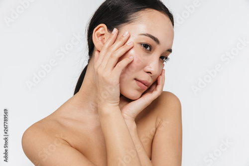 Asian woman posing naked isolated over white wall background.