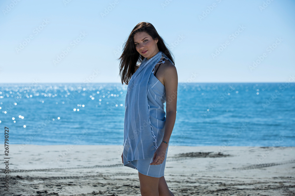 Pretty young girl wrapped in beach towel posing to the camera. Full length photo shoot and wonderful hair. Healthy, beauty and summer holiday concept. Pretty young girl wrapped in beach towel posing to the camera. Full length photo shoot and wonderful hair. Healthy, beauty and summer holiday concept.