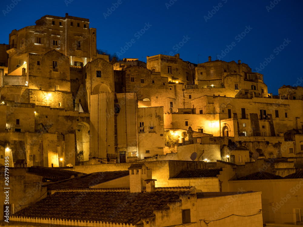 Fototapeta premium Italy - April, 2019: Amazing lighted buildings in ancient Sassi center by night in Sassi di Matera