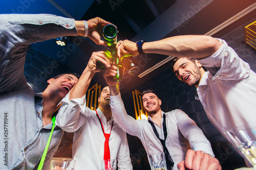 Group of young men toasting at a nightclub