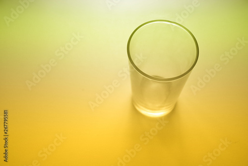 Un baso de cristal sobre fondo iluminado amarillo