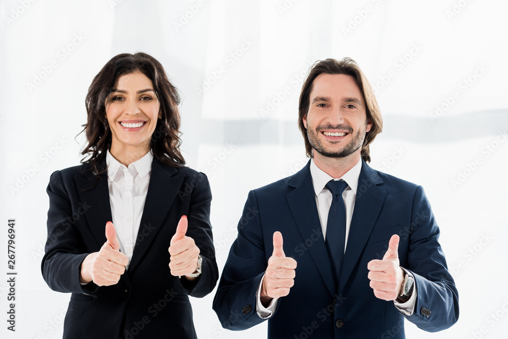 cheerful recruiters smiling while showing thumbs up and looking at camera cheerful recruiters smiling while showing thumbs up and looking at camera