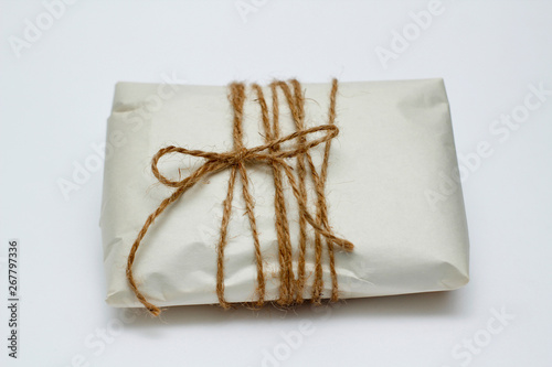 Old paper parcel with tie on white background.