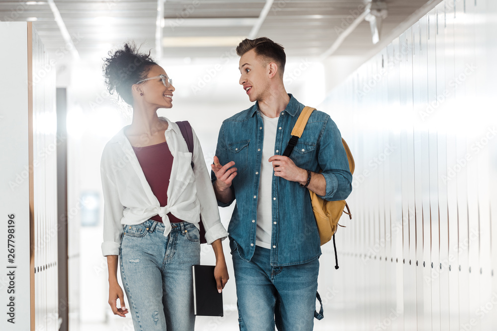 Fototapeta premium two multiethnic students looking at each other in corridor in university