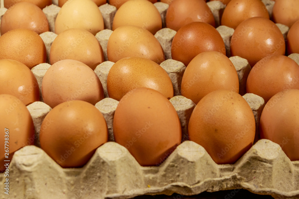 Raw chicken eggs in cardboard egg box close-up Raw chicken eggs in cardboard egg box close-up