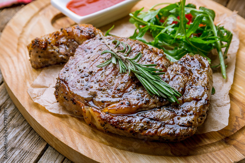juicy Ribeye steak on wooden background