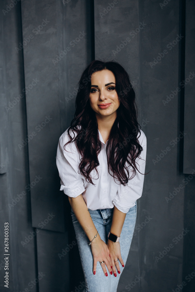 Photo session of a young brunette in jeans and a white shirt. Photo session of a young brunette in jeans and a white shirt.