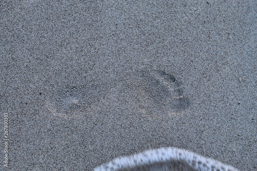Footprint in the sand with the water approaching from below