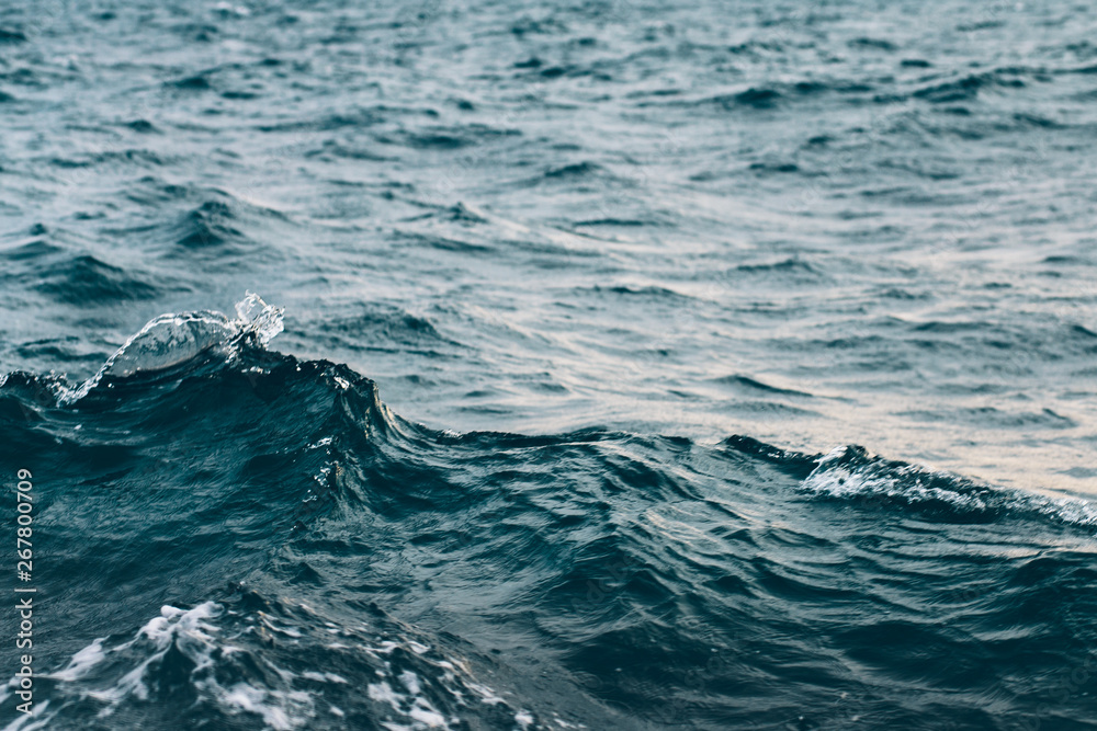 ripples on blue sea water with white foam , natural sea background ripples on blue sea water with white foam , natural sea background