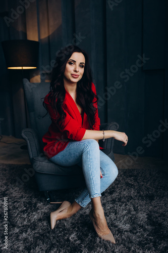 Photo session of a young brunette in jeans and a red jacket. © dimadasha