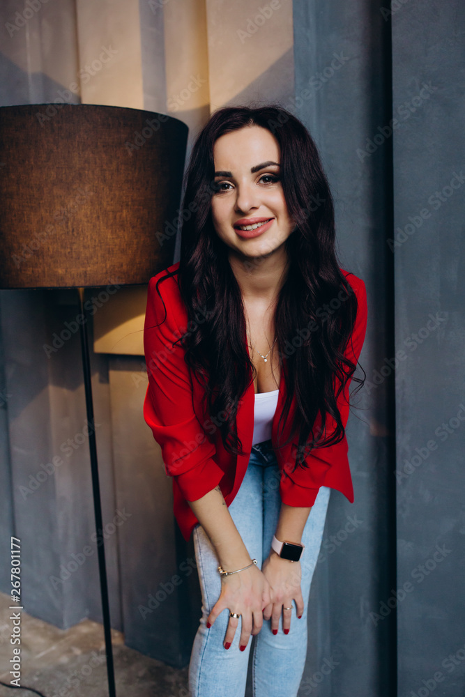 Photo session of a young brunette in jeans and a red jacket. Photo session of a young brunette in jeans and a red jacket.