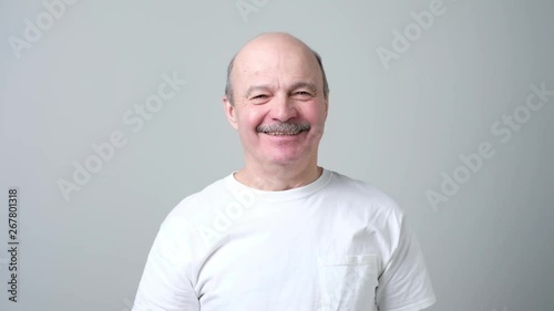 Senior man in white t-shirt send air kissing.