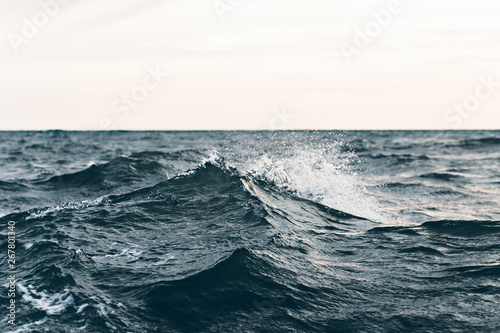 Fototapeta Naklejka Na Ścianę i Meble -  ripples on blue sea water with white foam , natural sea background