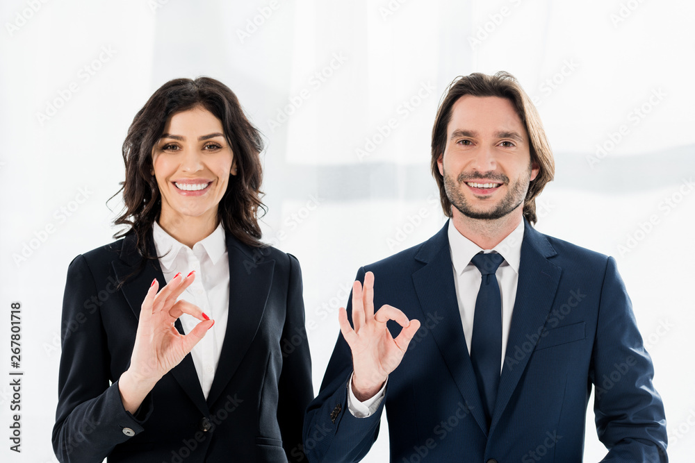 cheerful recruiters smiling while showing ok signs and looking at camera cheerful recruiters smiling while showing ok signs and looking at camera