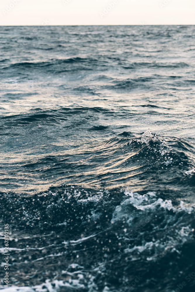 ripples on blue sea water with white foam , natural sea background ripples on blue sea water with white foam , natural sea background