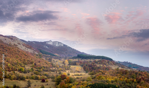 Panorama of stunning autumn colors of mountain forest and beautiful sunset sky © Nikola