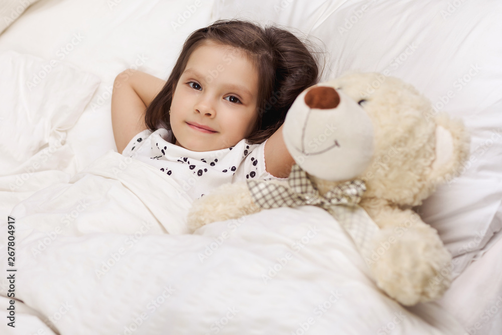 cute little child girl wakes up from sleep in bed in the morning cute little child girl wakes up from sleep in bed in the morning