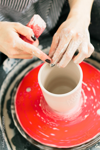 Women working on the potter's wheel in the studio, ceramic cup